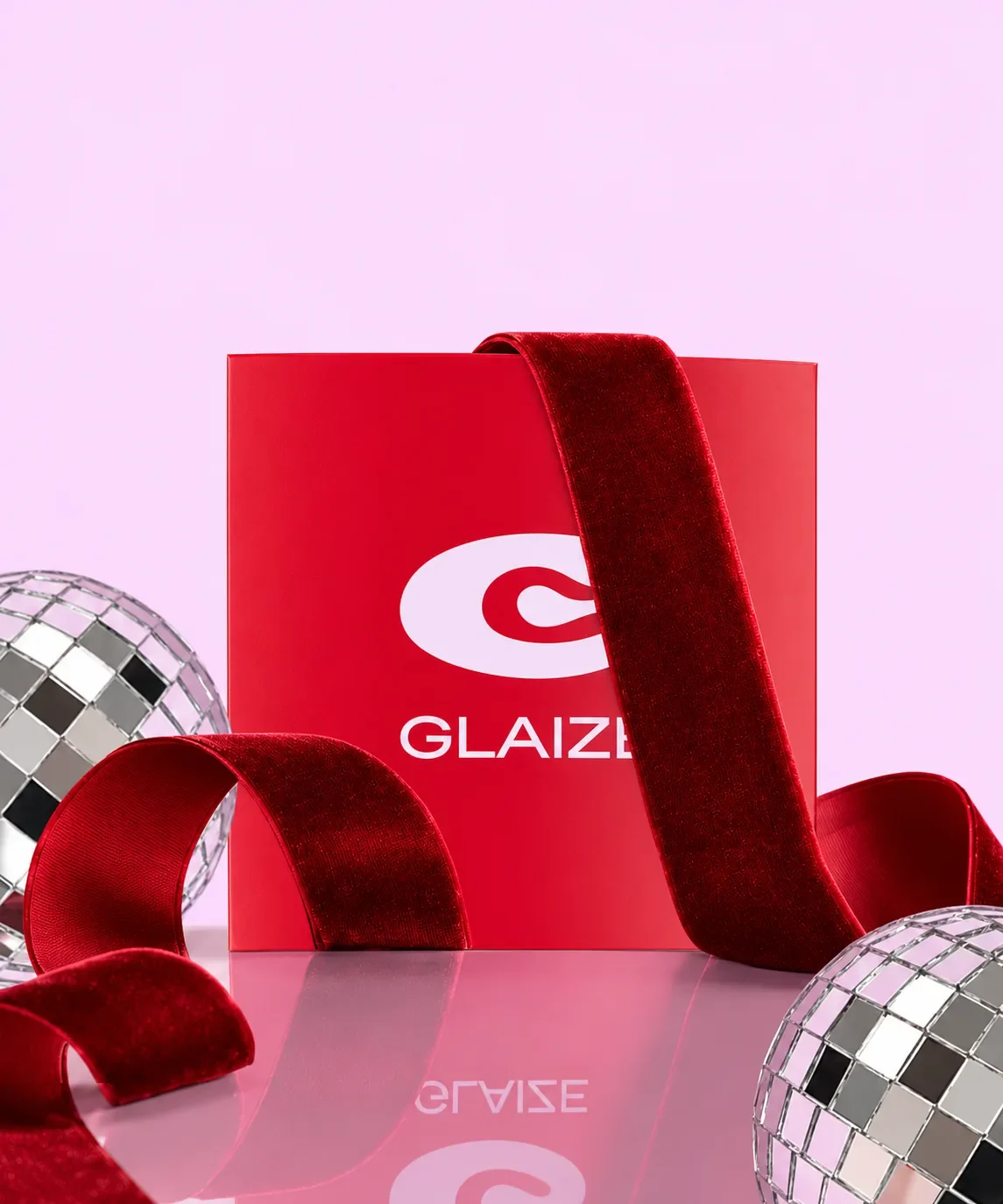 A red Glaize gift card with a velvet ribbon and disco balls