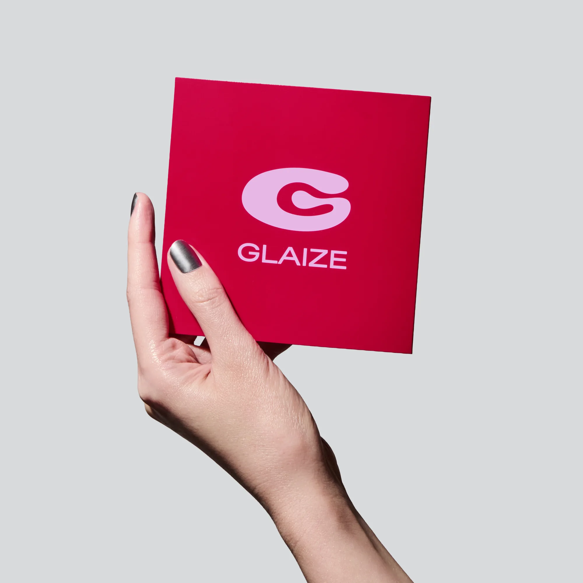 Hand holding Glaize maltese cross